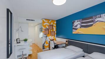 Una habitación de hotel moderna con cama, escritorio y kitchenette.