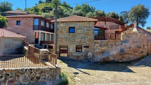 A stone building with a balcony and a stone wall. - For families who love nature and the countryside. (Celorico de Basto)