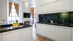 Una cocina moderna con armarios blancos, encimera de granito y estufa integrada.