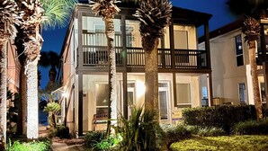 A two-story building with a balcony, surrounded by palm trees and a paved walkway. - [Summer Deals on remaining dates] 3 min to Beach! Waterfront, Pool, Beach gear (Destin)