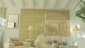 Una sala de estar moderna con un sofá, un sillón y una mesita con velas.