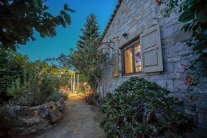 A stone building with a window and a stone wall. - Anthis Cottage (Malevizi)