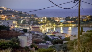 A coastal town at dusk with buildings, a marina, and boats. - Anthis Cottage (Malevizi)