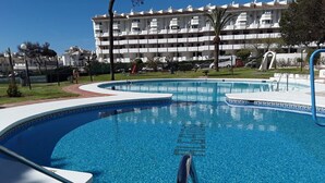 A swimming pool with a clear blue water, surrounded by a white building with balconies. - Calahonda Royale Apartment Edif Lirio, Mijas Costa by Holidays & Home (Malga)