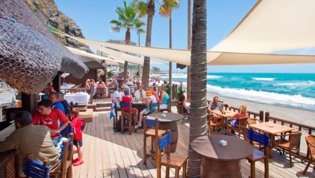 A beachside restaurant with outdoor seating, palm trees, and ocean views. - Calahonda Royale Apartment Edif Lirio, Mijas Costa by Holidays & Home (Malga)