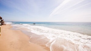 Une plage avec un rivage sablonneux et un ciel dégagé.