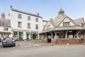 A street with a building labeled 'HOME COMING' and another with a sign 'Homecoming.' There's a car parked on the street. - House - Sleeps 6 & Paid off Site Parking Available (Minehead)