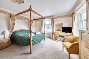 A bedroom with a four-poster bed, a desk with a television, and a chair. - House - Sleeps 6 & Paid off Site Parking Available (Minehead)