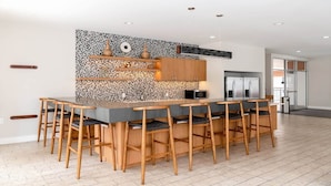 Una cocina moderna con una isla central, sillas de madera y un salpicadero con diseño.
