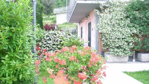 A garden with potted plants and a building with a balcony. - Appartameto wi fi, Natura , Relax (minucciano)
