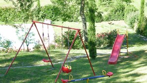 A playground with swings, a slide, and a seesaw. - Appartameto wi fi, Natura , Relax (minucciano)
