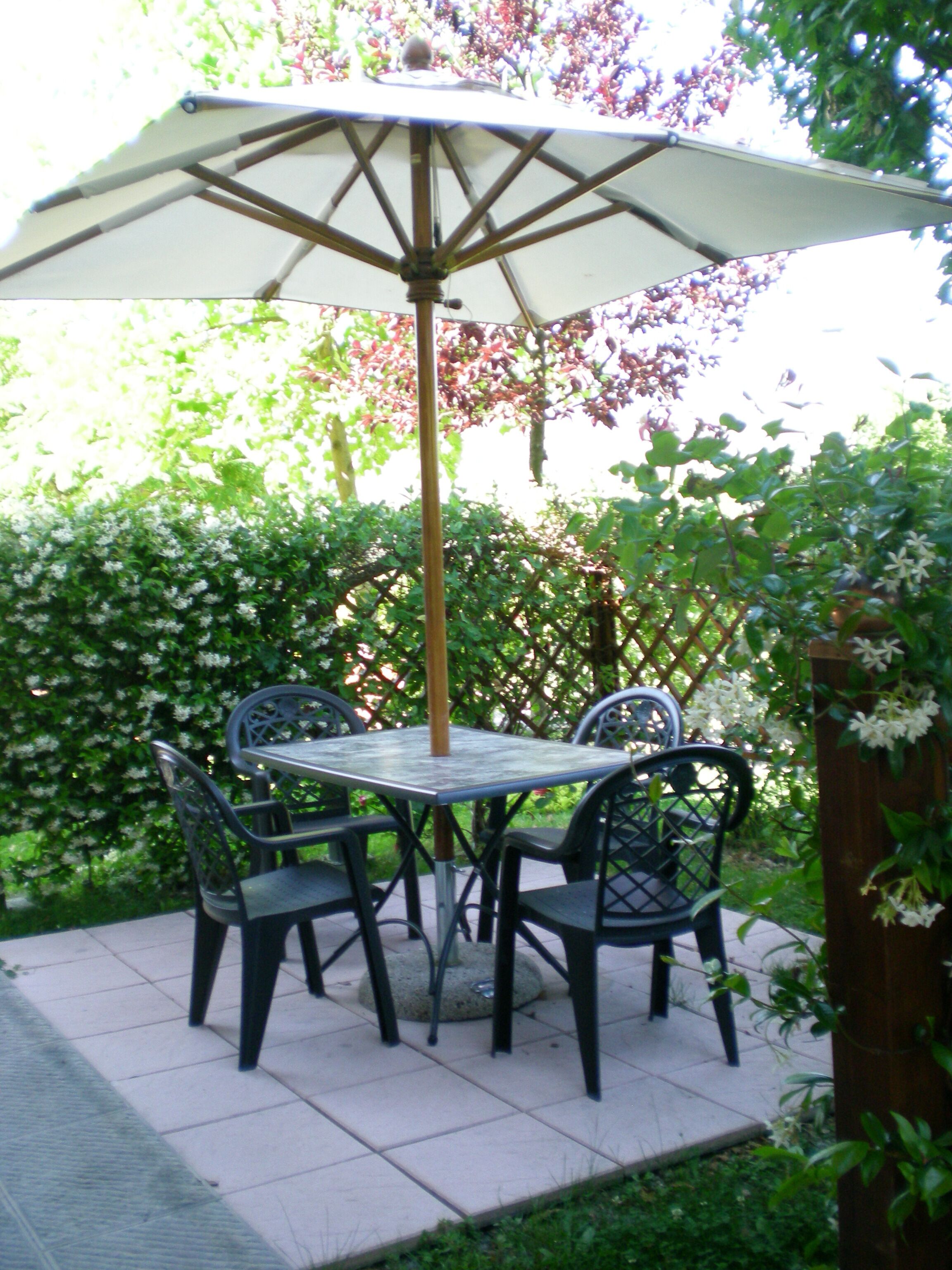A patio table with four chairs and a large umbrella.