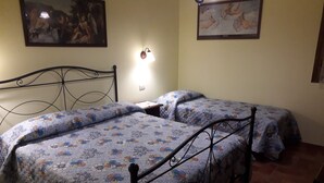 A bedroom with two single beds, a nightstand, a wall-mounted lamp, and two framed pictures. - Appartameto wi fi, Natura , Relax (minucciano)