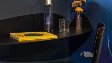 Ein Tisch mit einem Buch, einer Glasflasche und einer Vase mit Blumen.