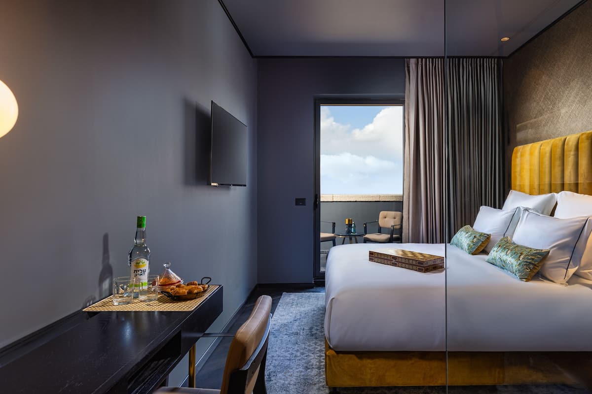 Ein modernes Hotelzimmer mit Bett, Schreibtisch und Fernseher.