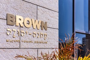 Un letrero de edificio con el nombre 'BROWN' y 'MACHNE YEHUDA JERUSALEM' en inglés y hebreo.