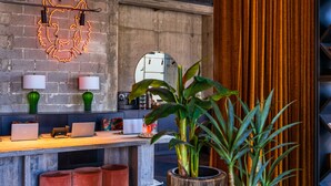 A modern kitchen with a wooden countertop, two laptops, a coffee machine, and a large potted plant. - Brown Machne Yehuda (Jerusalem)
