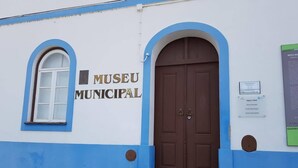 Un edificio con un letrero que dice "MUSEU MUNICIPAL" y una puerta marrón.