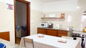 A small kitchen with a dining table, microwave, and stove.