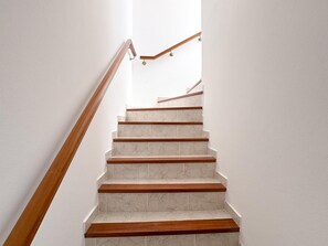 A staircase with wooden handrails and white marble steps.