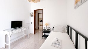 Une chambre à coucher moderne, équipée d’un lit, d’un bureau, d’une télévision et d’une lampe.