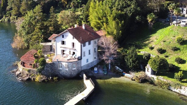 A white house with a red roof on a lakeside property. - Appartamento Ca Bianca  (Cannobio)