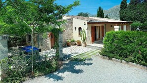 A house with a stone facade, a tiled roof, and a gravel driveway. - Villa Almendra Boi, Mallorcan country house with modern touches (Pollença)