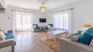 A modern living room with a sofa, armchairs, a coffee table, and a TV. - Villa Brisa do Mar | 4 Bedrooms | Walking Distance | Galé (Galé)