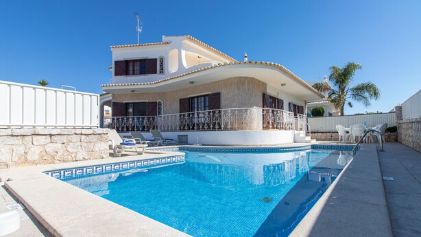 A two-story house with a swimming pool, stone wall, and white railing. - Villa Brisa do Mar | 4 Bedrooms | Walking Distance | Galé (Galé)