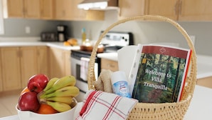 Una cocina con una cesta de mimbre que contiene un libro, una botella de Lysol y un paño.