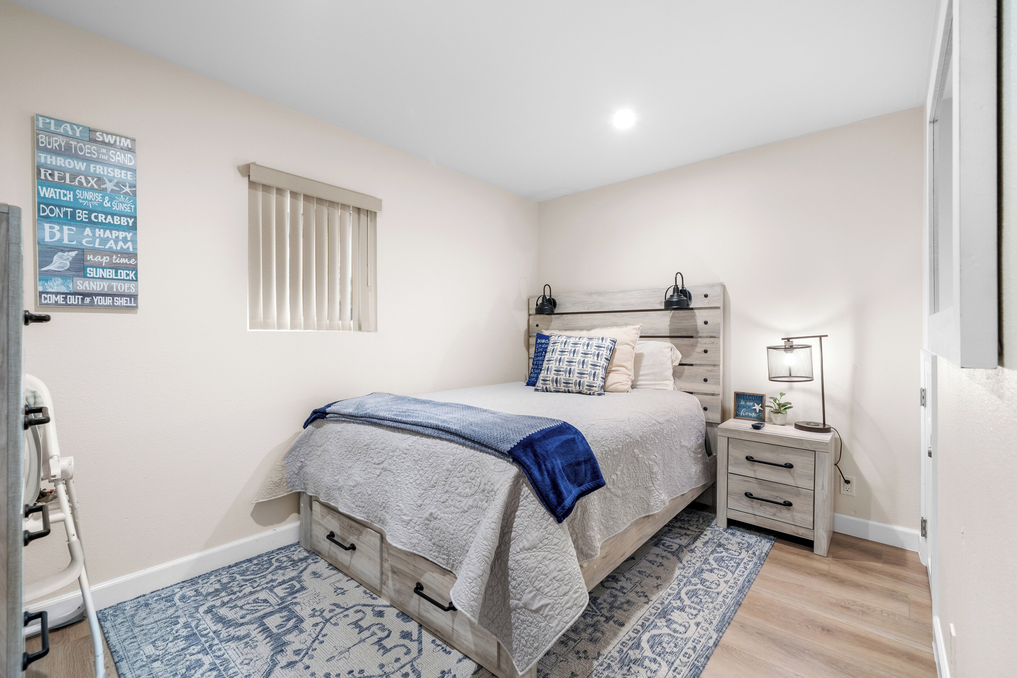 Ein Schlafzimmer mit Bett, Nachttisch und Wand mit motivierenden Zitaten.