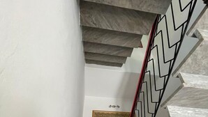 Eine Treppe mit einer Zickzack-Metallreling und einem Marmorboden.