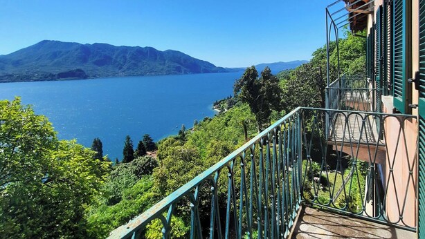 Een balkon met uitzicht op een meer en bergen.
