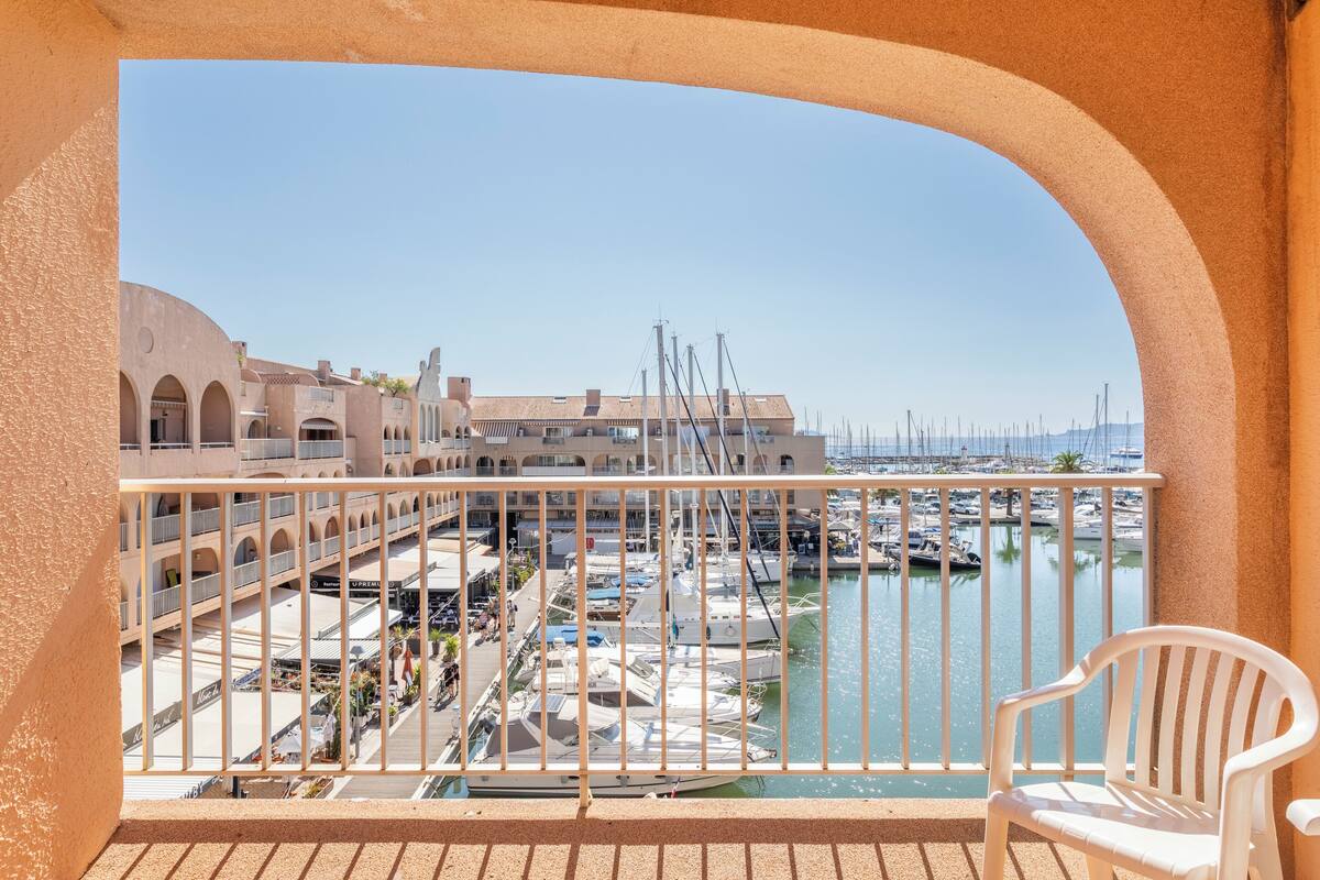 Ein Balkon mit Blick auf einen Yachthafen und Gebäude.