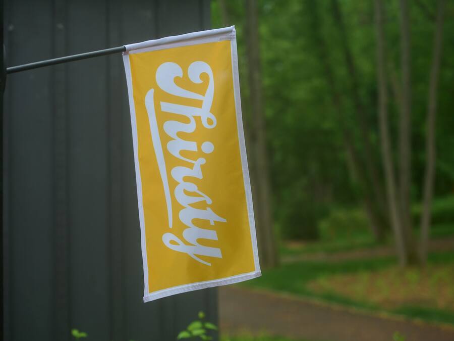 A yellow sign with the word "Thirty" in white cursive text.