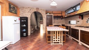Una cocina compacta con refrigerador, microondas y una mesa de comedor con sillas.
