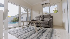 Ein modernes Wohnzimmer mit einem grauen Sofa, einem Holztisch und einem Streifen Teppich.