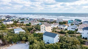 Un quartier résidentiel situé sur la côte, avec des maisons, une plage et une vue sur l’océan.