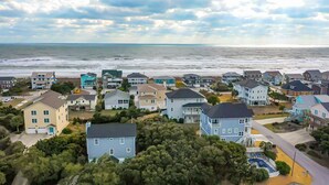 Una zona residencial costera con casas, una playa y un cielo despejado.