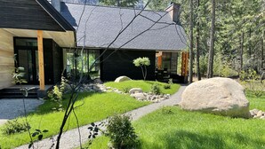 Une maison moderne avec un chemin de pierre menant à une terrasse en bois.
