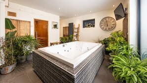 A modern bathroom with a large bathtub, potted plants, and a wooden ladder shelf. - Manse On The Beach (Portaferry)