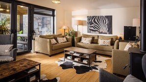 A modern living room with two sofas, a coffee table, and a fireplace. - Manse On The Beach (Portaferry)