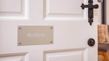 Una puerta blanca con una placa que dice "Marlfield" y un picaporte negro.