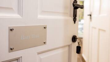 A white door with a metal plate labeled "Barr Hall".