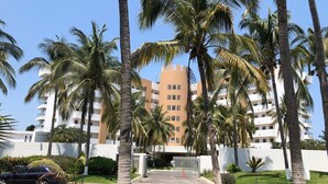 Un hotel de diseño moderno, con un patio central rodeado de palmeras y un área de estacionamiento.