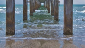 Ein Steg, der sich ins Meer erstreckt, gestützt von mehreren Betonpfeilern.