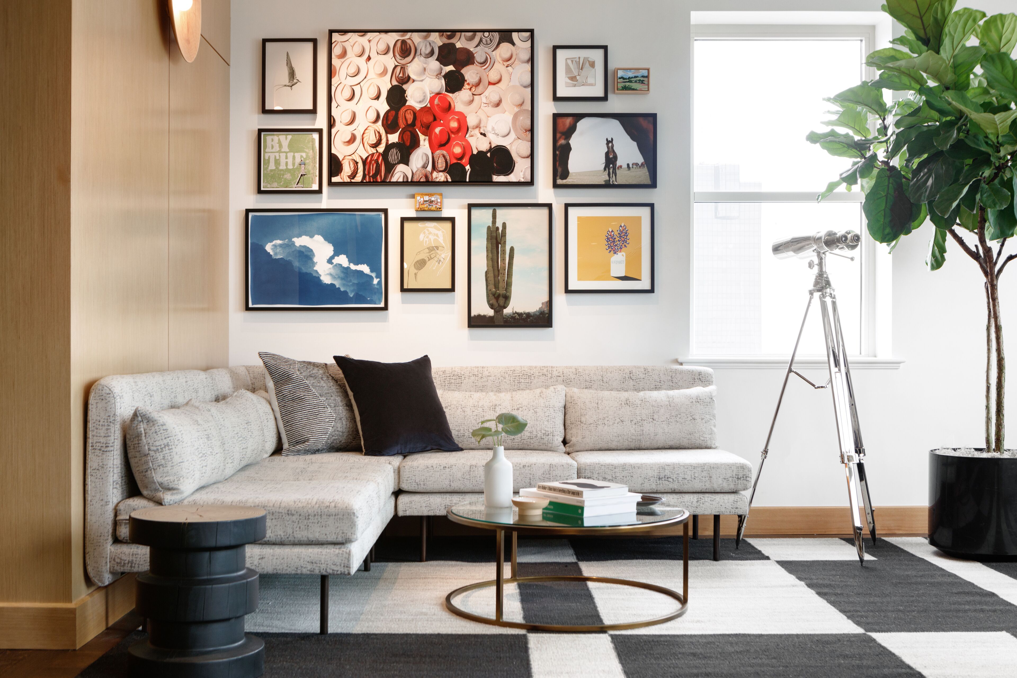 A modern living room with a sectional sofa, a coffee table, and a large potted plant.