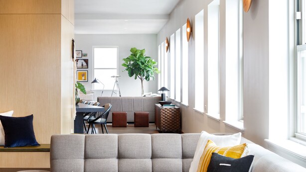 A modern living room with a sectional sofa, a coffee table, and a dining area in the background. - Kimpton Harper Hotel by IHG (Fort Worth)