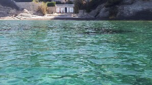 A clear view of a waterfront area with a building and trees in the background. - Studio - quiet seaside location with private parking (La Ciotat)