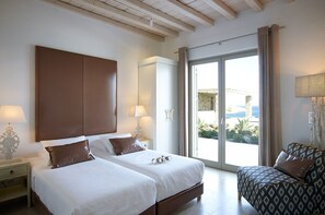 A hotel room with two beds, a sofa, a large window, and a view of the outside.
